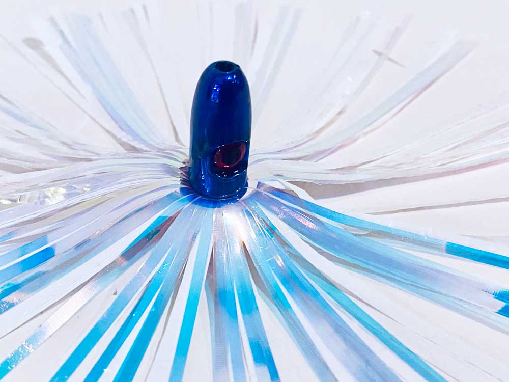 Mylar Duster Lure 4.5" Pearl White Crinkle - close up of 1oz navy blue lead head with red eye