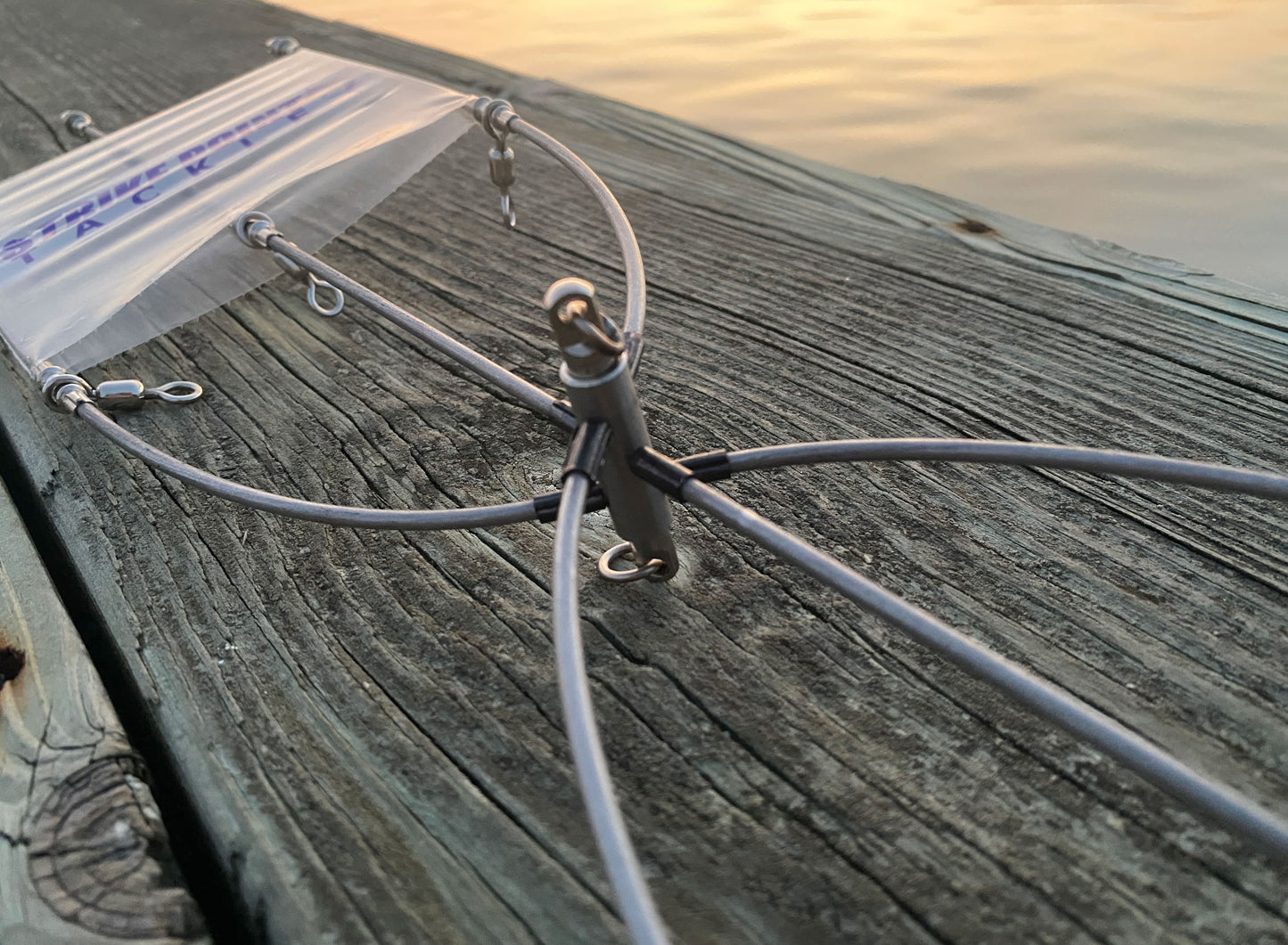 24 inch stainless steel dredge bar hardware detail - swivels and center connector at sunset
